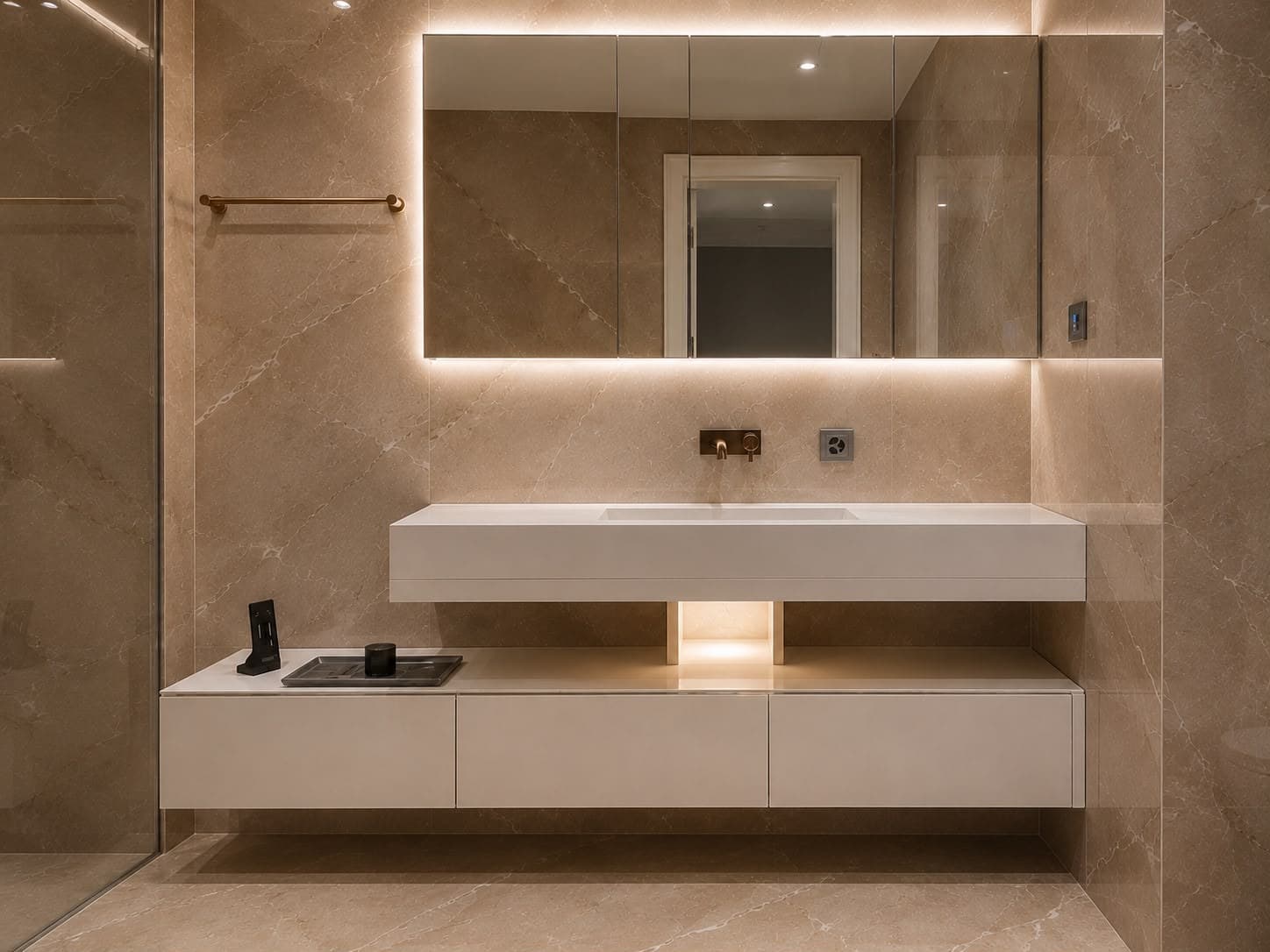 Salle de bain en pierre beige avec meuble vasque suspendu blanc et miroir rétroéclairé